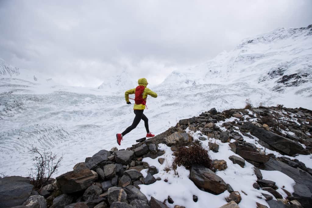 Female trail runner in snow mountain