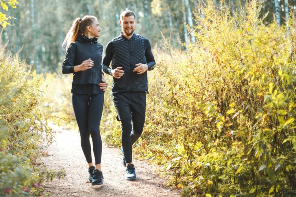 man and woman running together in the park