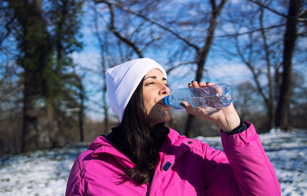 athlete drinking water before training on snow