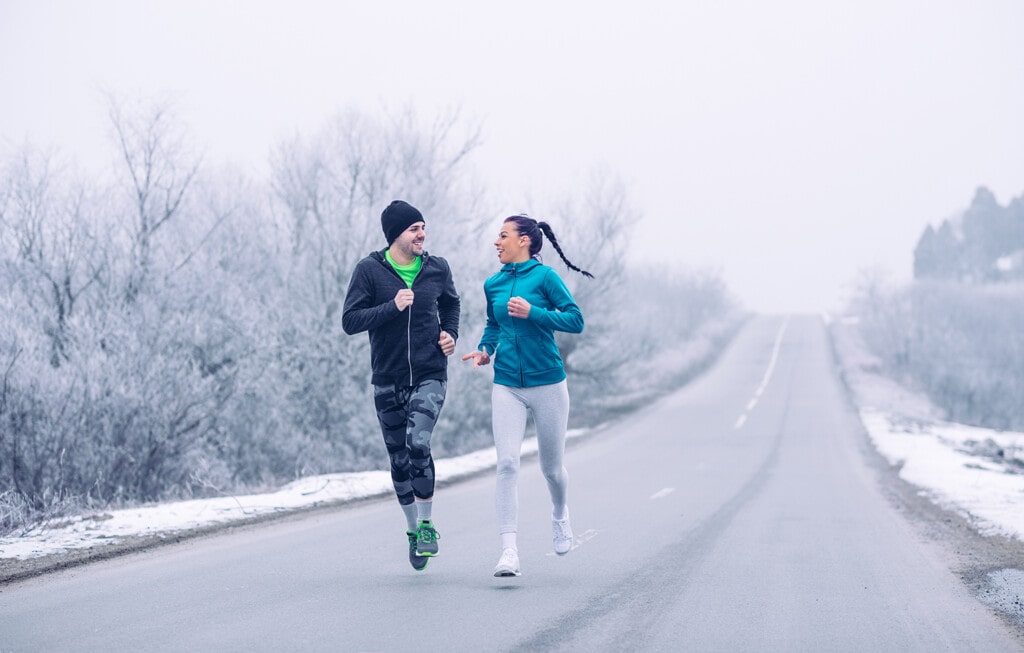 young couple running in the winter