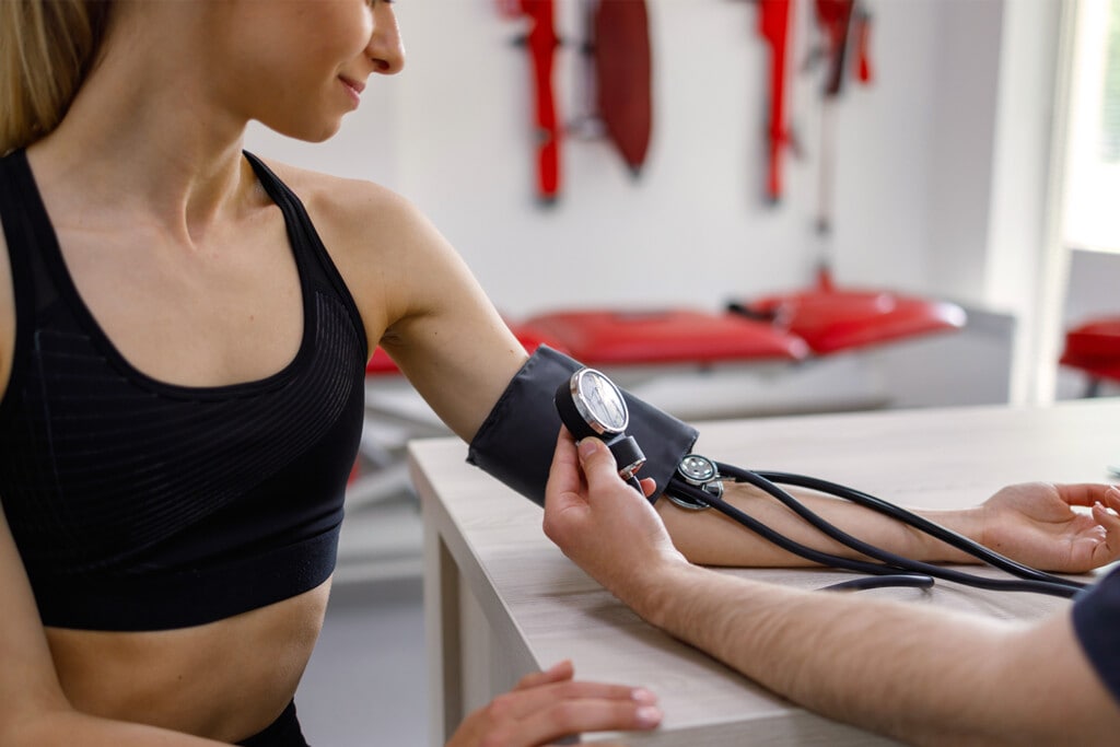 doctor measuring blood pressure of a female runner