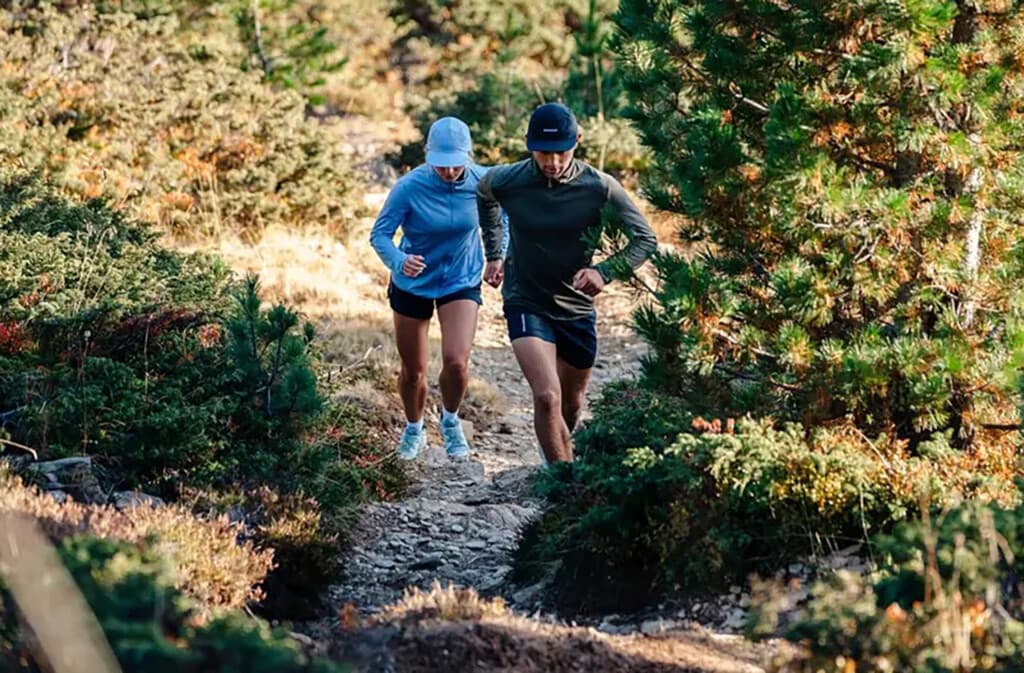 couple running on a trail wearing Salomon running shoes