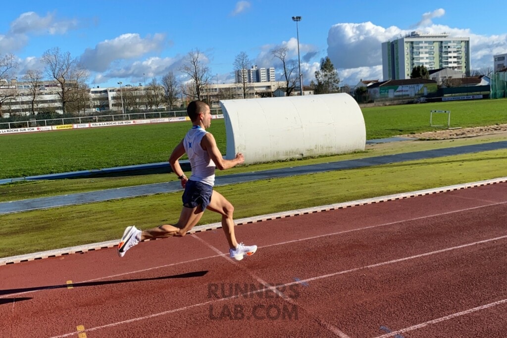 athlete running on track with nike carbon plate shoes
