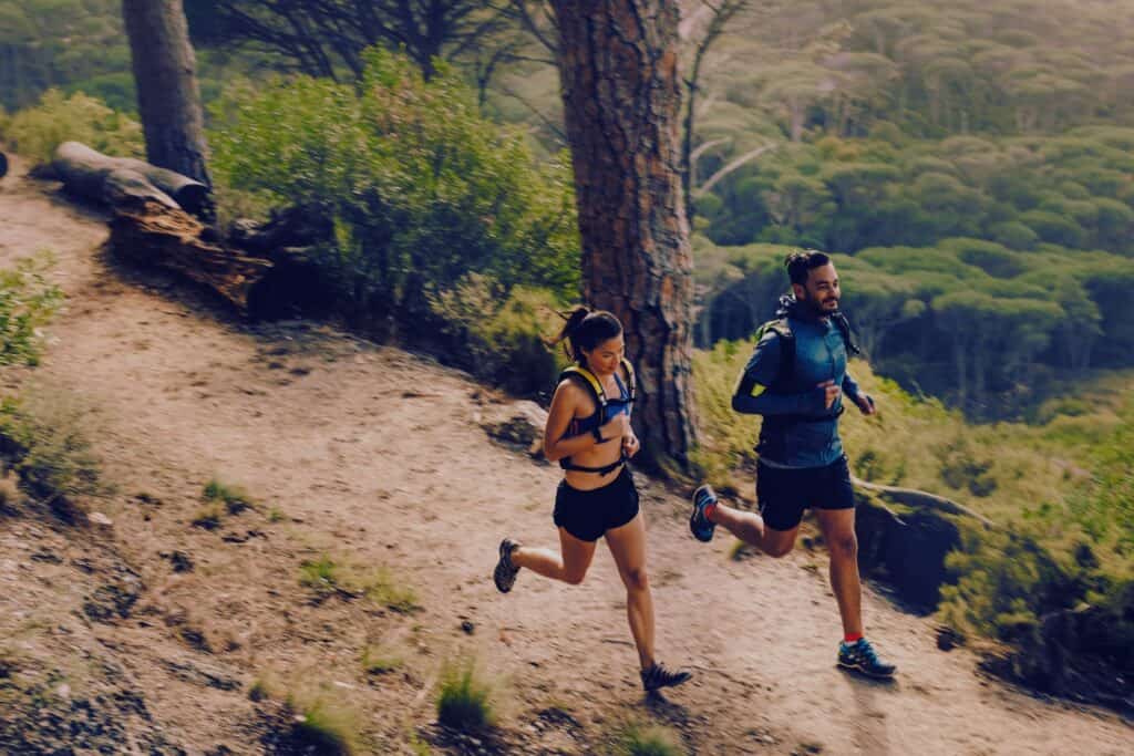 Man and woman trail running on a trail